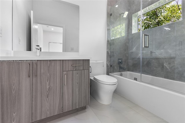 full bathroom featuring vanity, combined bath / shower with glass door, and toilet