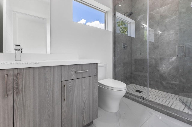 bathroom with vanity, toilet, and a shower with door