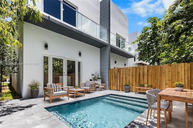 back of house with a fenced in pool, outdoor lounge area, and a patio area