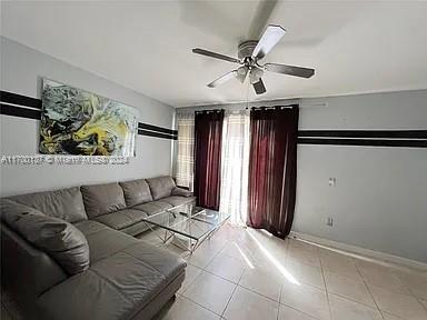 tiled living room with ceiling fan