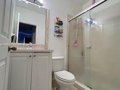 bathroom with vanity, toilet, walk in shower, and a notable chandelier