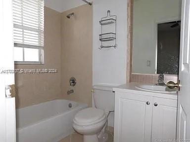 full bathroom with vanity, tiled shower / bath combo, and toilet