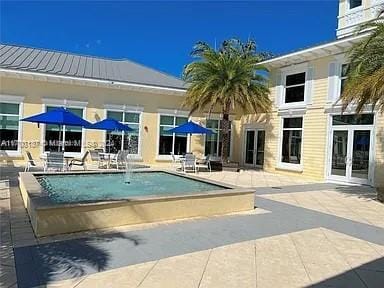 view of pool with french doors and a patio