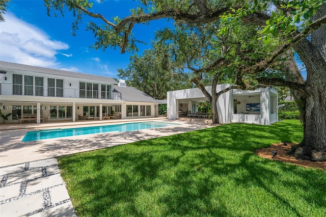 view of pool with a patio area and a yard