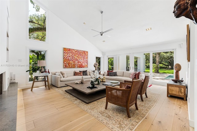 living room featuring ceiling fan, light wood-type flooring, high vaulted ceiling, and french doors