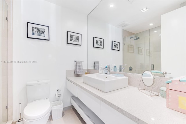 bathroom with tile patterned flooring, vanity, a shower with shower door, and toilet