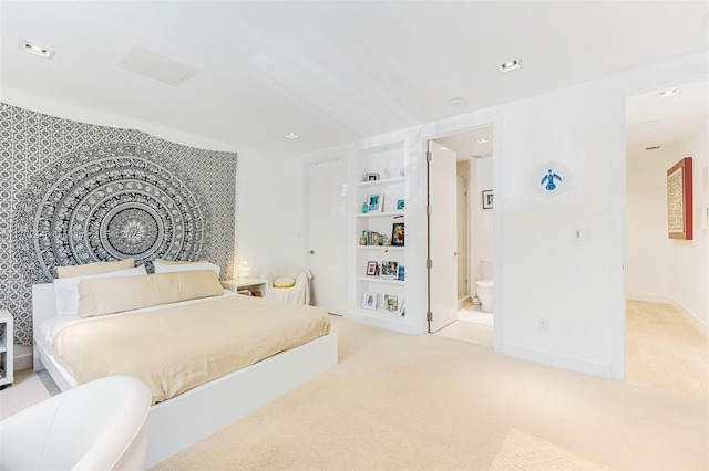 bedroom featuring light colored carpet and ensuite bath