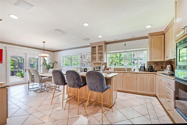 kitchen with pendant lighting, plenty of natural light, light brown cabinets, and appliances with stainless steel finishes