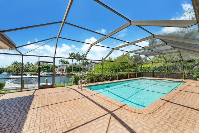 view of swimming pool with glass enclosure, a water view, and a patio