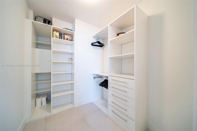 walk in closet with light tile patterned flooring