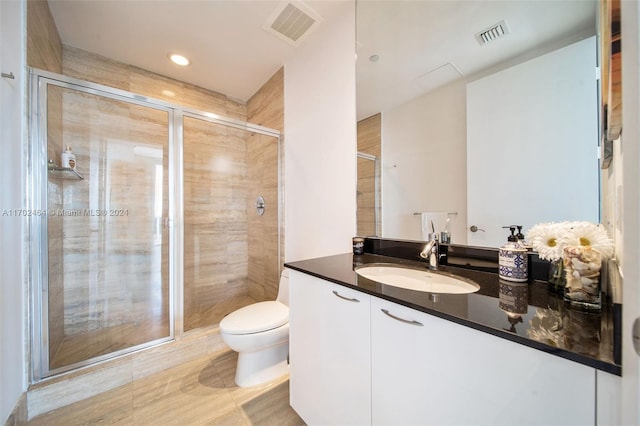 bathroom with tile patterned flooring, vanity, toilet, and a shower with door