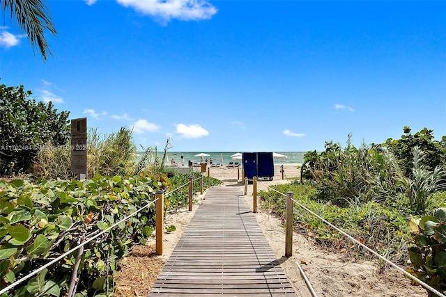 view of property's community featuring a water view and a beach view