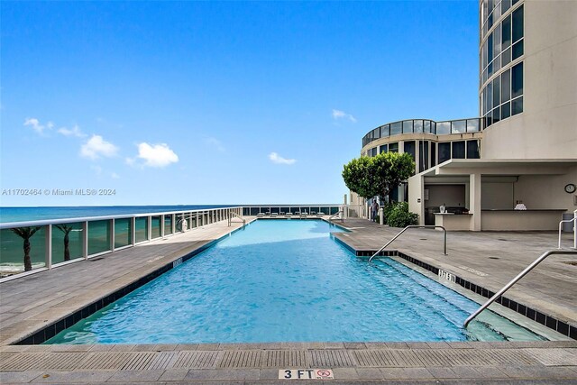 view of pool featuring a patio area and a water view