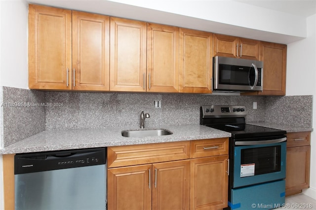 kitchen featuring appliances with stainless steel finishes, backsplash, and sink