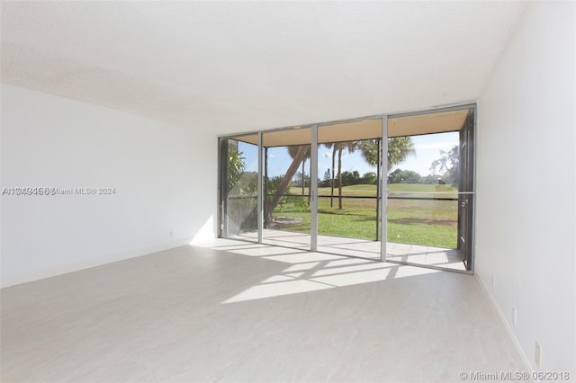 unfurnished room featuring a textured ceiling and floor to ceiling windows