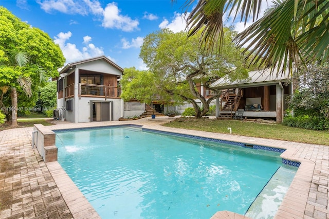 outdoor pool with stairway, a lawn, and a patio