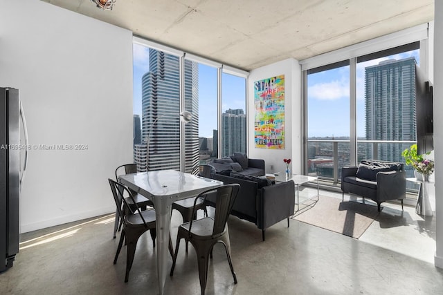 dining area with concrete floors and a wall of windows