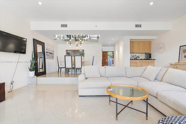 tiled living room featuring a notable chandelier