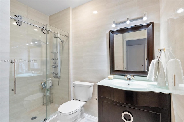 bathroom with vanity, an enclosed shower, tile walls, and toilet