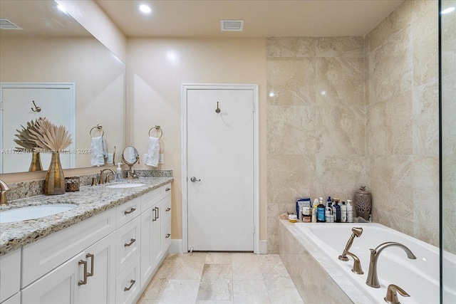 bathroom featuring vanity, tile walls, and tiled tub