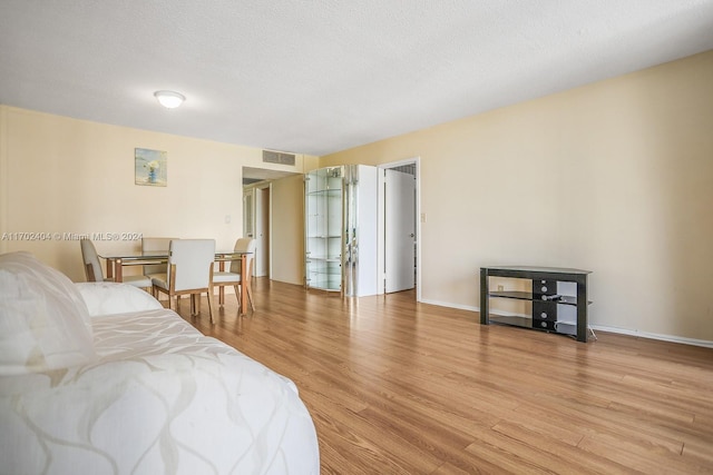 bedroom with light hardwood / wood-style flooring and a textured ceiling