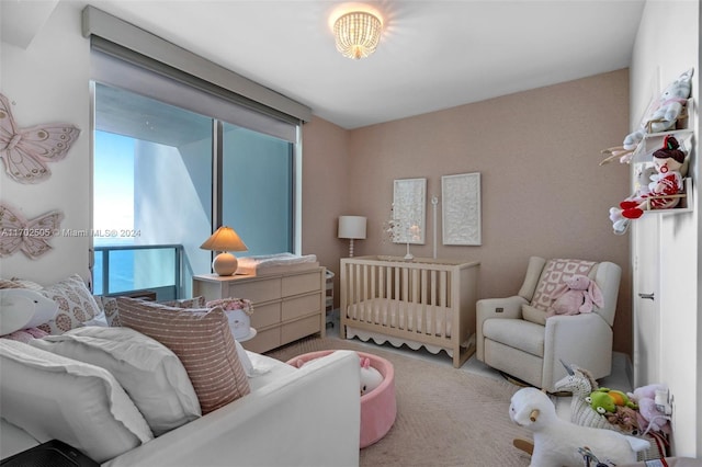 carpeted bedroom featuring a nursery area