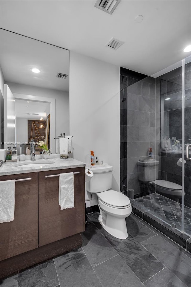 bathroom featuring vanity, toilet, and walk in shower