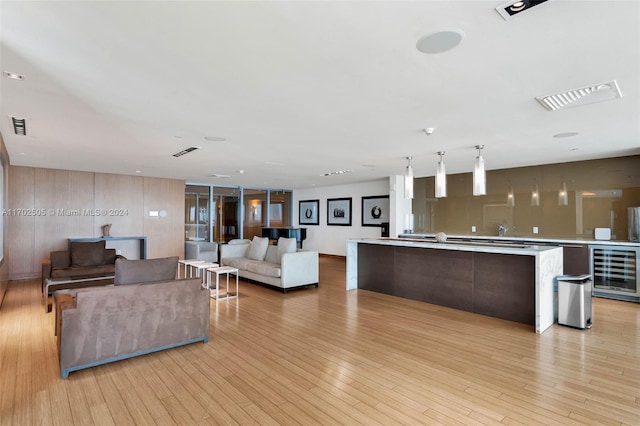 living room featuring beverage cooler and light hardwood / wood-style flooring