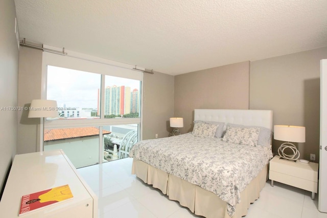 tiled bedroom with access to exterior and a textured ceiling