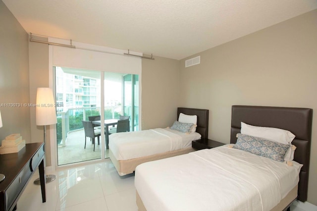 bedroom with light tile patterned flooring, access to exterior, and a textured ceiling