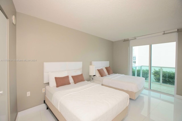 tiled bedroom with access to exterior and a textured ceiling