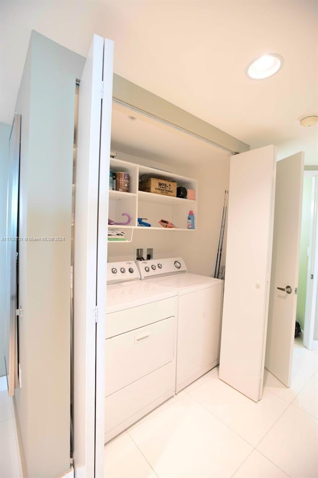 washroom featuring light tile patterned floors and washer and clothes dryer