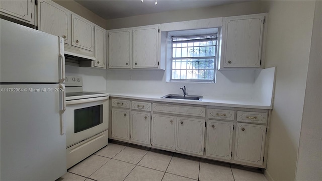 kitchen featuring light tile patterned flooring, white appliances, white cabinets, and sink