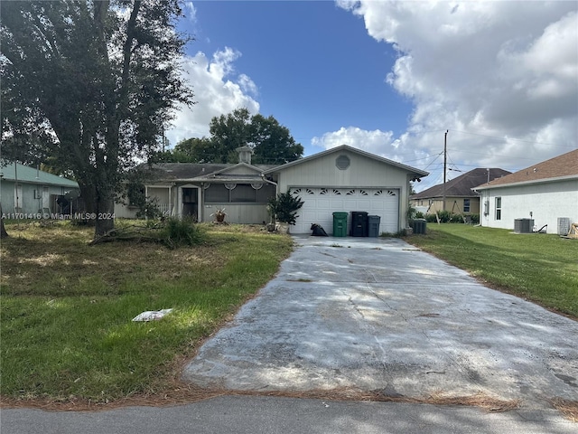 ranch-style house featuring a front yard, a garage, and central AC unit