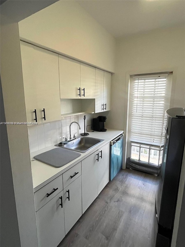 kitchen featuring tasteful backsplash, stainless steel appliances, sink, hardwood / wood-style flooring, and white cabinetry