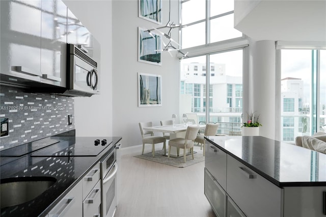 kitchen with backsplash, plenty of natural light, and stainless steel appliances