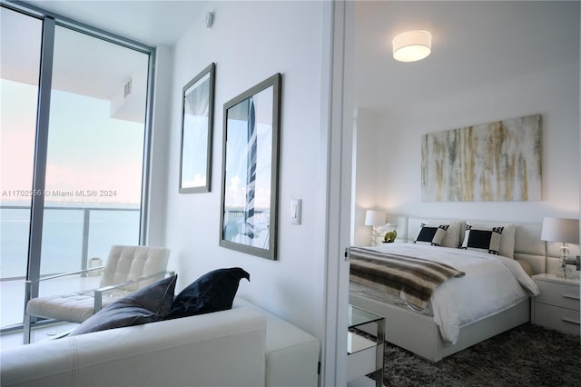 carpeted bedroom featuring a water view