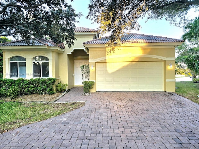 mediterranean / spanish-style house with a garage