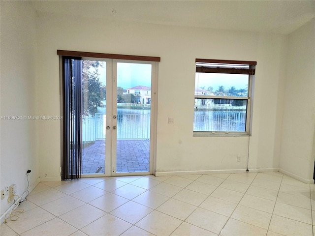 spare room with light tile patterned floors and french doors