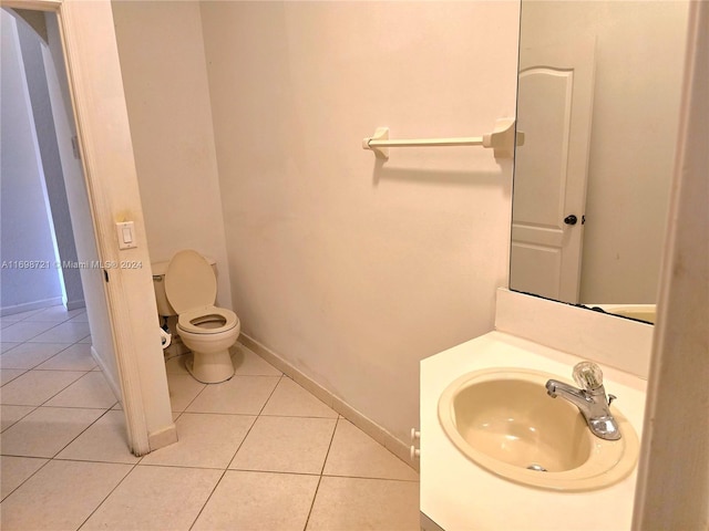 bathroom with toilet, tile patterned floors, and sink