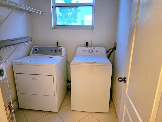 washroom with washer and clothes dryer and light tile patterned floors