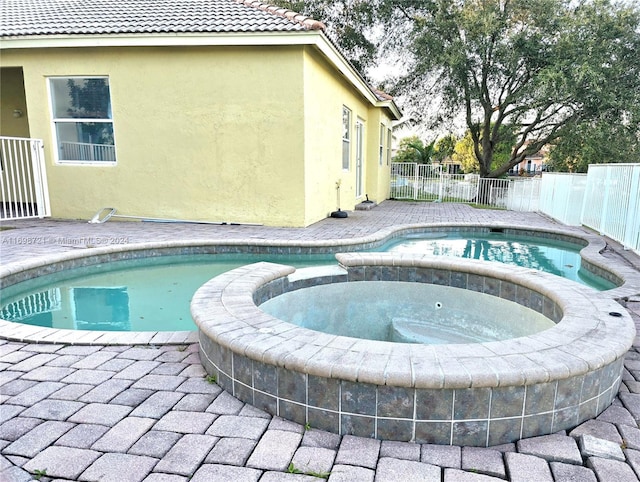 view of swimming pool featuring an in ground hot tub