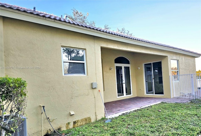 back of property with a lawn, a patio area, and central AC unit