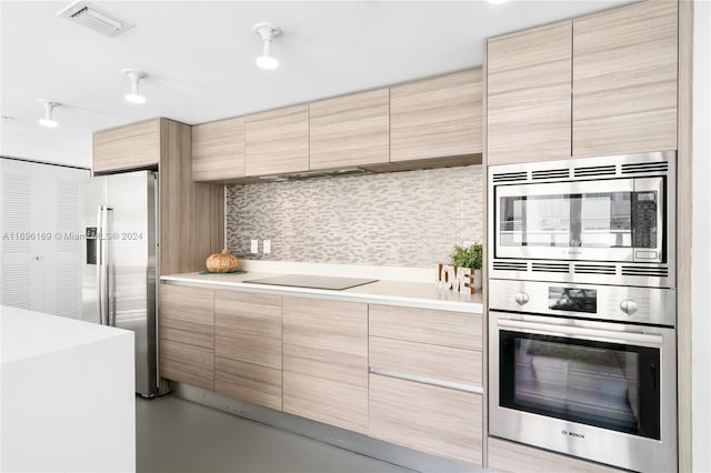 kitchen with backsplash, light brown cabinetry, and stainless steel appliances