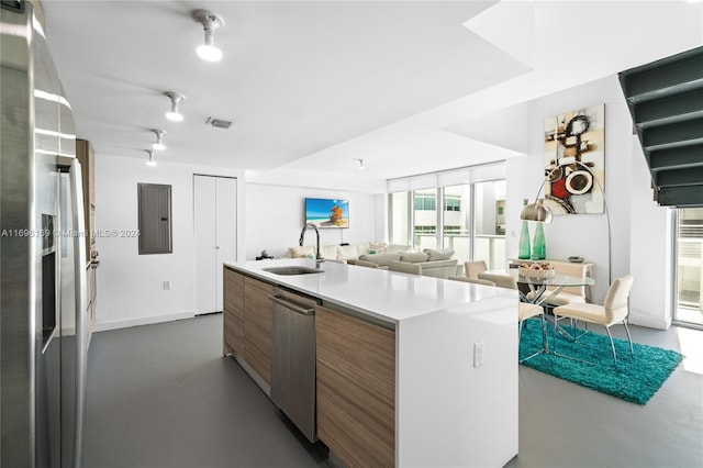 kitchen with appliances with stainless steel finishes, electric panel, a kitchen island, and sink