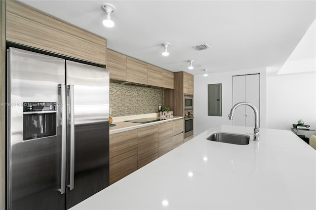 kitchen with built in appliances, backsplash, and sink