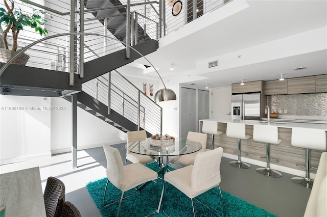 dining room with sink and a high ceiling