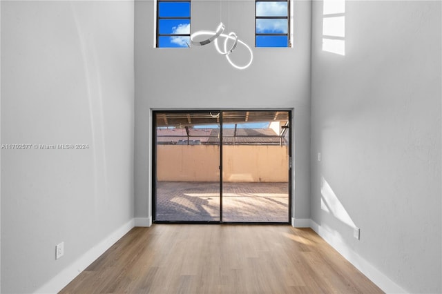 interior space with hardwood / wood-style floors and a towering ceiling