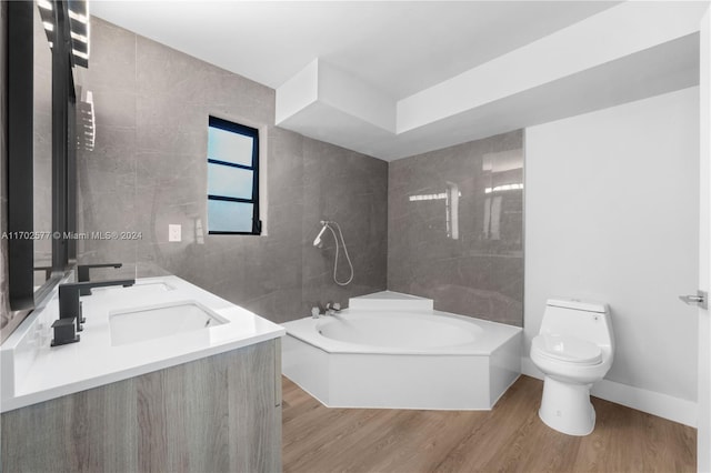 bathroom with hardwood / wood-style floors, vanity, toilet, and a tub