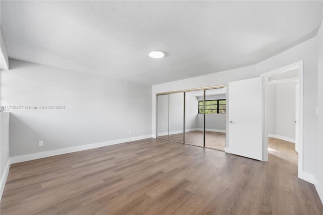 unfurnished bedroom featuring a closet and hardwood / wood-style flooring